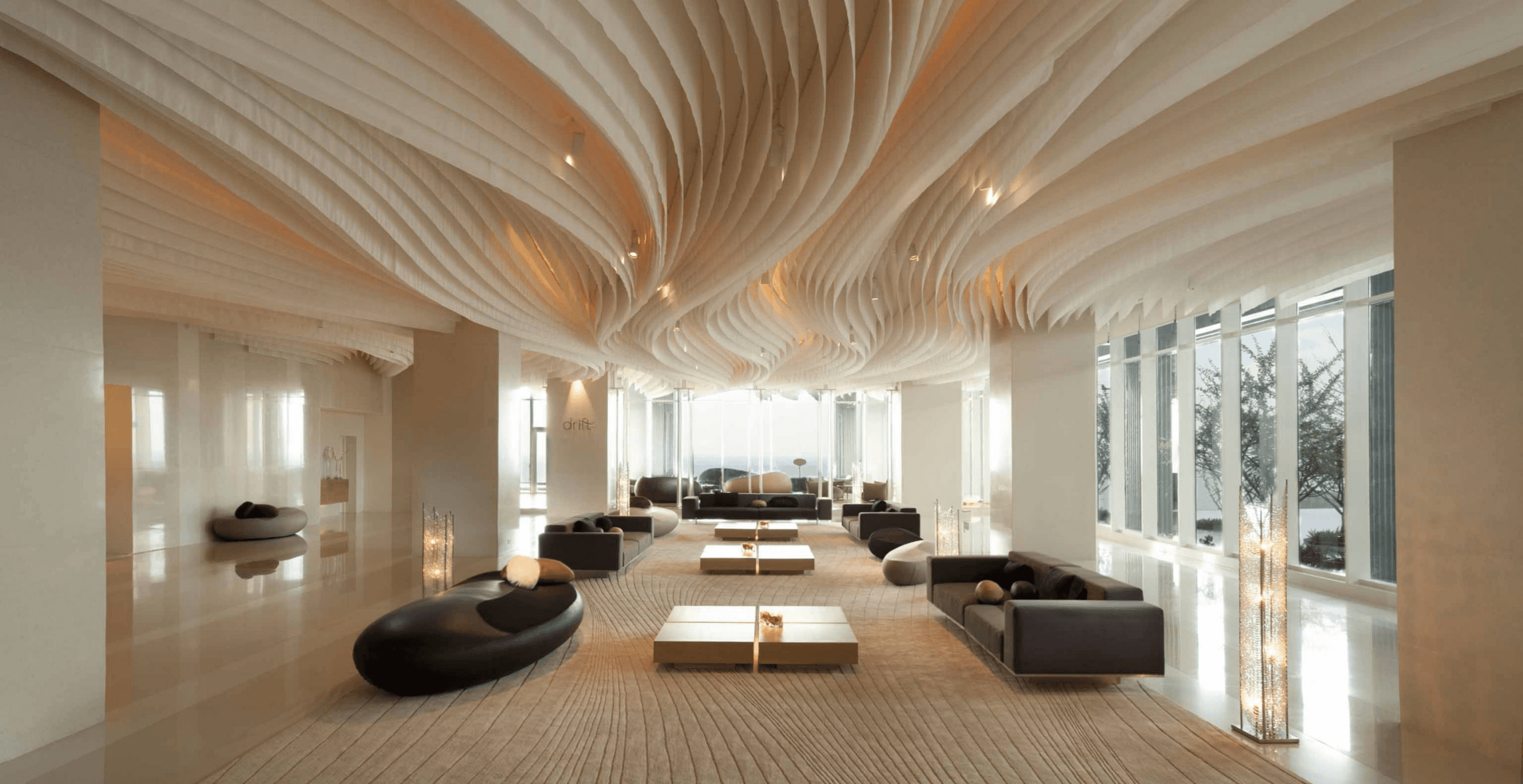 Modern hotel lobby with sculptural ceiling and lounge seating